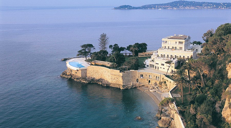 View from the sea of ultra luxury Hotel Cap Estel, featuring its seaside pool and private peninsula setting on the French Riviera.