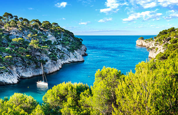 Aerial view of the Calanques of Cassis, featuring dramatic limestone cliffs and turquoise Mediterranean waters in southern France.