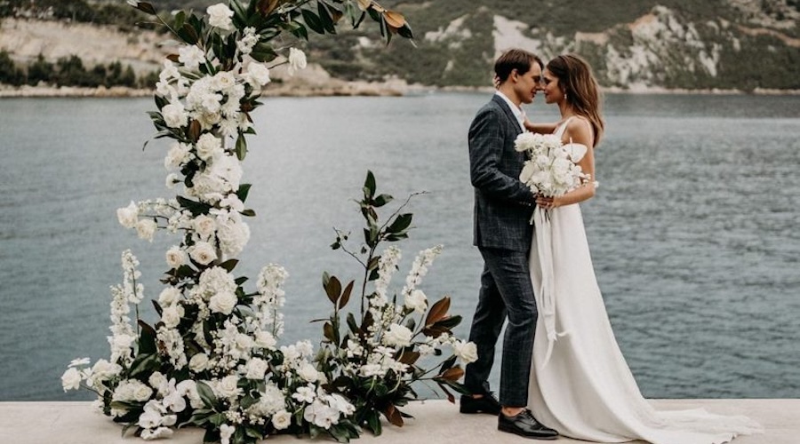Couple exchanging vows during a luxury waterfront wedding ceremony by the Mediterranean Sea.